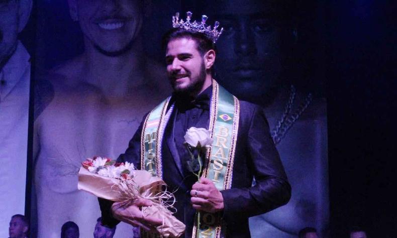 Bernardo Rabello foi o vencedor do primeiro Mister Brasil Trans (foto: Tomás Araújo) Vencedor do Mister Brasil Trans usando terno preto portando a faixa de vencedor, coroa e buquê de flores