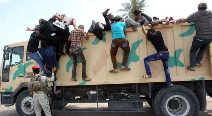 Iraquianos xiitas sobem em caminhão para alistamento de tropas contra forças rebeldes sunitas que atacam o país(foto: ALI AL-SAADI/AFP) Iraquianos xiitas sobem em caminhão para alistamento de tropas contra forças rebeldes sunitas que atacam o país(foto: ALI AL-SAADI/AFP)