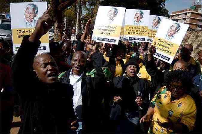 Simpatizantes cantam e fazem oraes durante viglia na porta de hospital onde Mandela est internado(foto: AFP PHOTO / FILIPPO MONTEFORTE )