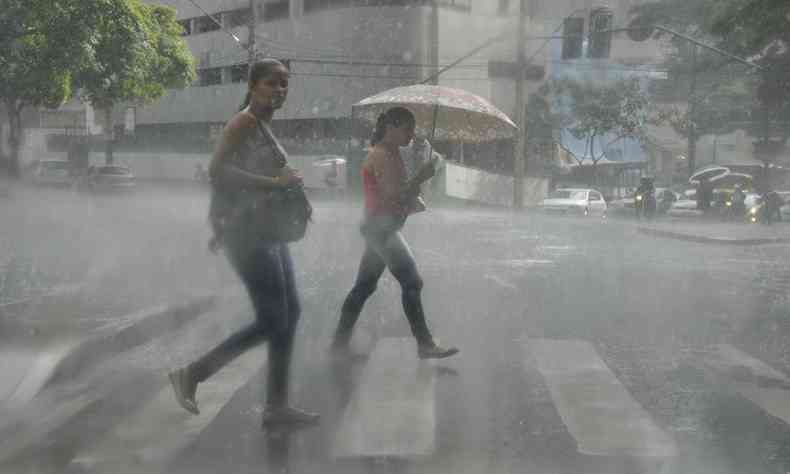 uma mulher sem sombrinha na chuva e outra com se protegendo dela 