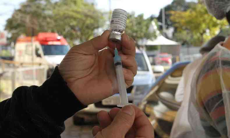 Enfermeira segurando seringa com a vacina contra a COVID-19