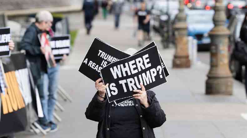 Mulher segura cartaz %u2018Onde est Trump?%u2019