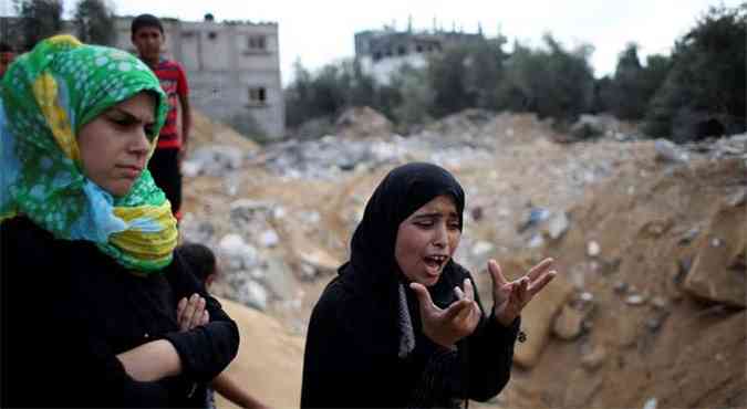 Familiar de vtima de bombardeio israelense grita diante dos escombros da casa de parentes mortos(foto: REUTERS/Ibraheem Abu Mustafa)