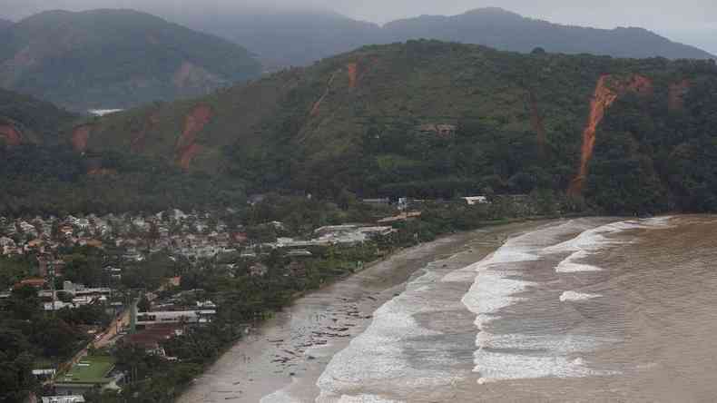 Foto area mostra praia e encostas com deslizamentos