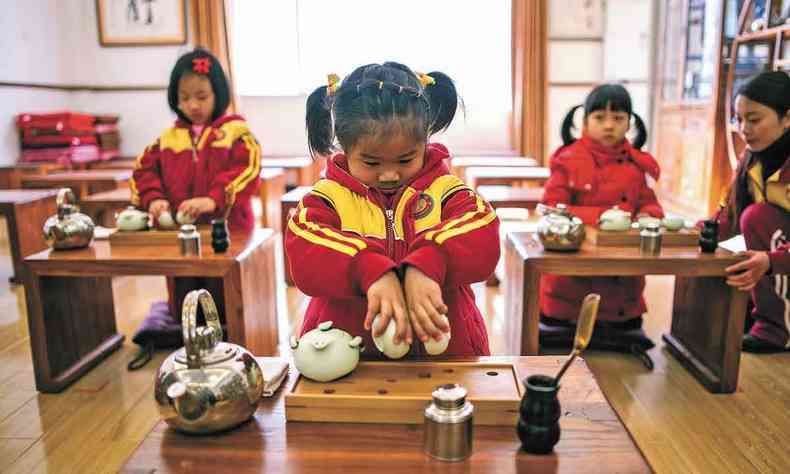  Crianas chinesas diante de bules e xcaras aprendem a cerimnia do ch