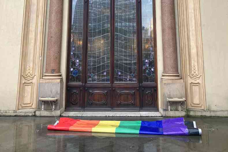 Bandeira com as cores do arco-ris estendida no cho em frente  entrada do Theatro Municipal de So Paulo