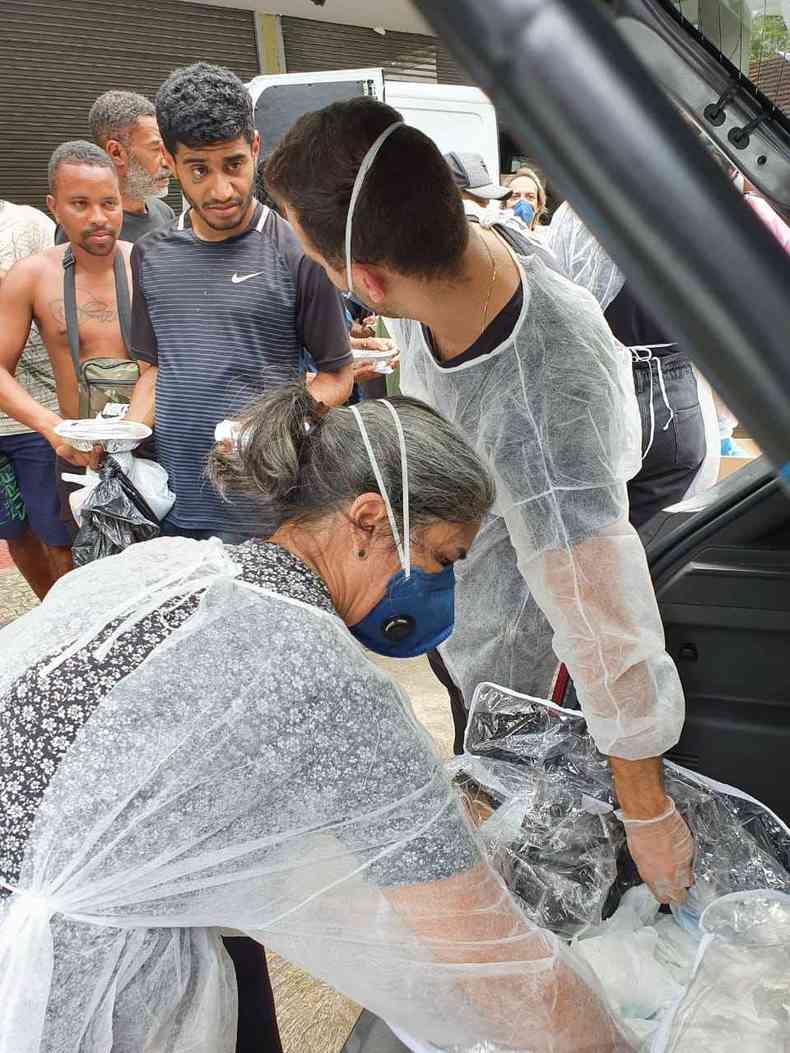 Alimentos, gua e kits de higiene foram distribudos por voluntrios usando mscaras e aventais para se proteger do coronavrus(foto: Pastoral de Rua de Belo Horizonte)
