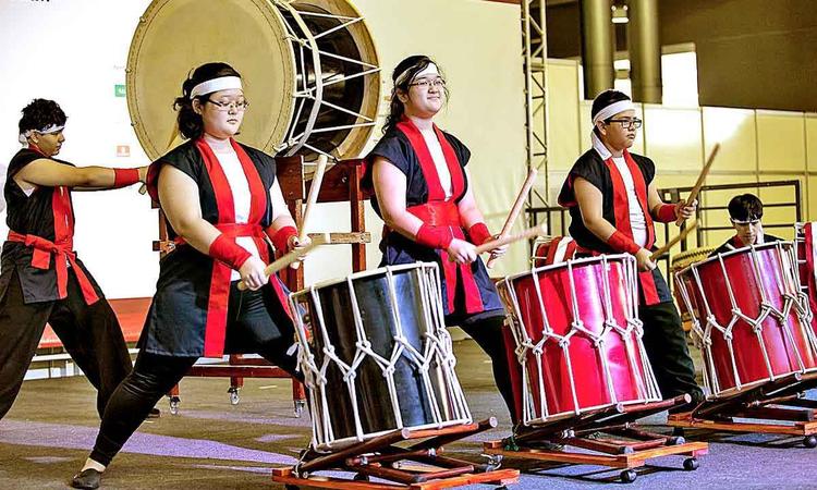 Artistas tocam tambores japoneses no palco