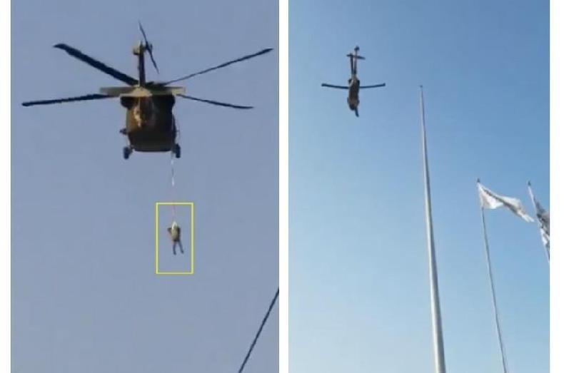 Capturas de tela feitas em 1 de setembro de 2021 de um vdeo mostrando um homem pendurado de um helicptero (E) e um helicptero ao lado de vrios mastros, no Afeganisto ( . / )