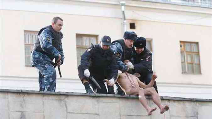 Policiais russos prenderam o artista ainda sangrando durante o protesto(foto: Oksana Shalygina/Reproduo/Facebook)