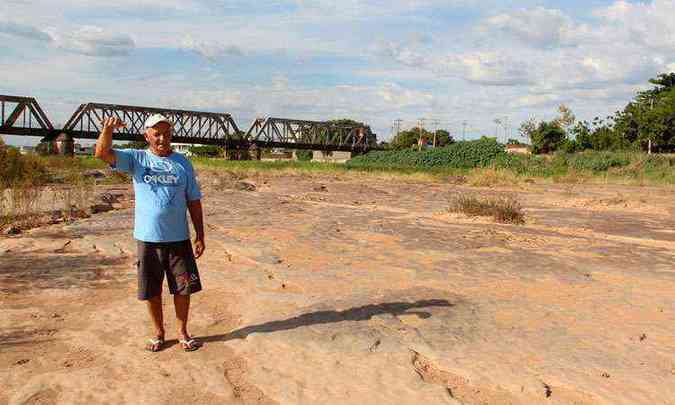 Pescador Josu Reis da Costa caminha no leito seco do rio em Pirapora e mostra que o nvel deveria estar com pelo menos 1,5 metro de profundidade(foto: APARCIO MANSUR/ESP. EM)