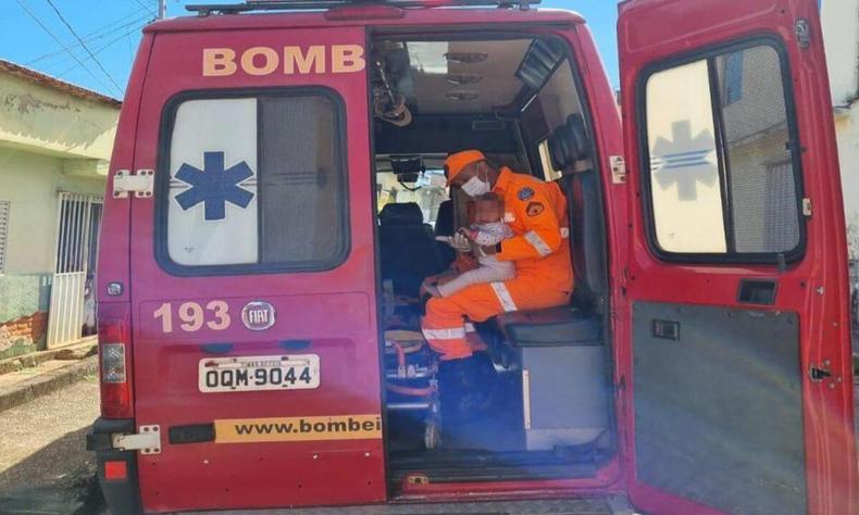 Agente do CBMMG com uma criana socorrida dentro do veculo da corporao