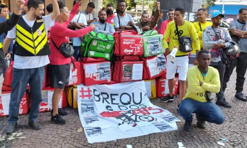 Motociclistas entregadores reunidos com sinais e faixas de protesto por melhores condies de trabalho