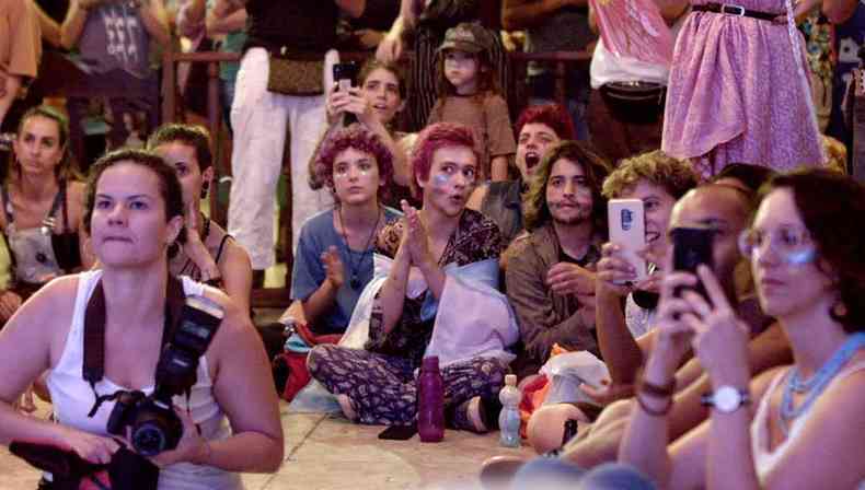 Grupo de jovens com rostos pintados e sentados no cho no filme Germino ptalas no asfalto