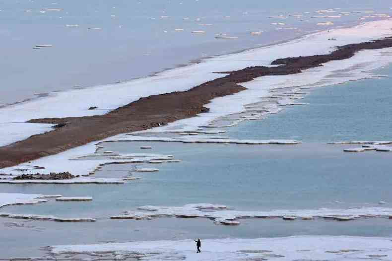 Homem caminha em formaes de sal ao longo do Mar Morto
