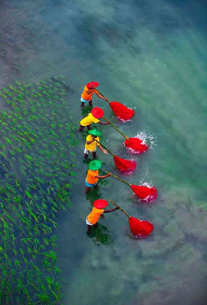 People fish with nets in a river in Sirajgong, Bangladesh