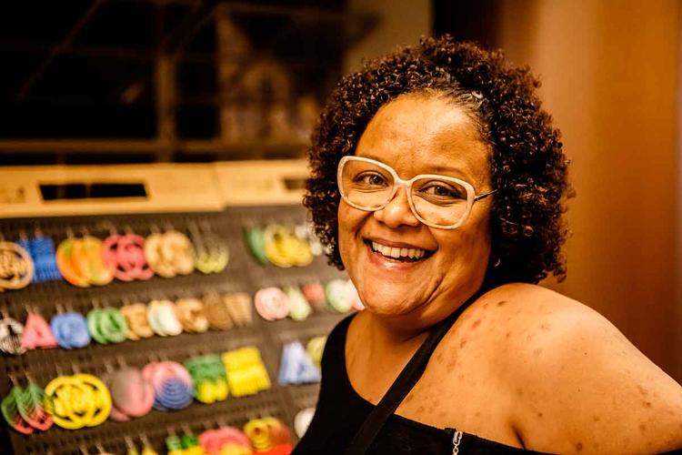 De blusa preta, a produtora Karu Torres sorri para a cmera
