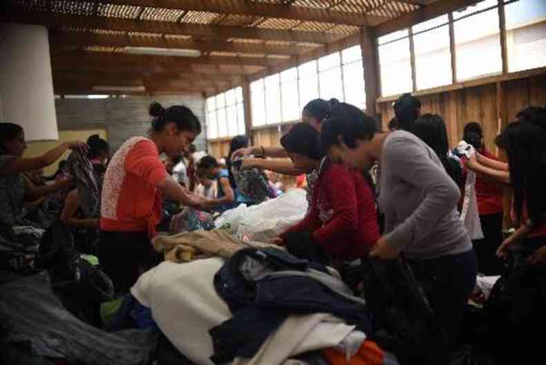 Voluntrios classificam donativos para a populao afetada pelas inundaes e deslizamentos (foto: JOHAN ORDONEZ/AFP)