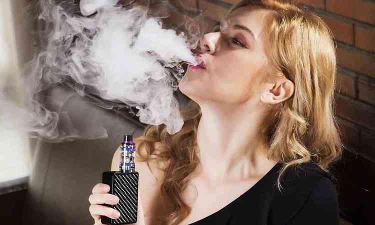 mulher loira fuma cigarro eletrnico