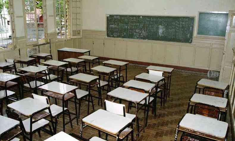 Sala de aula vazia com um quadro negro no fundo