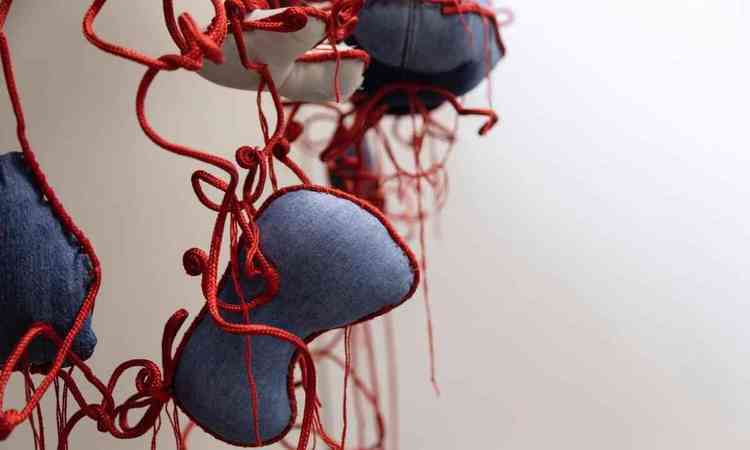 Peas de jeans presas por croch vermelho criadas pela artista Ana Bouissou