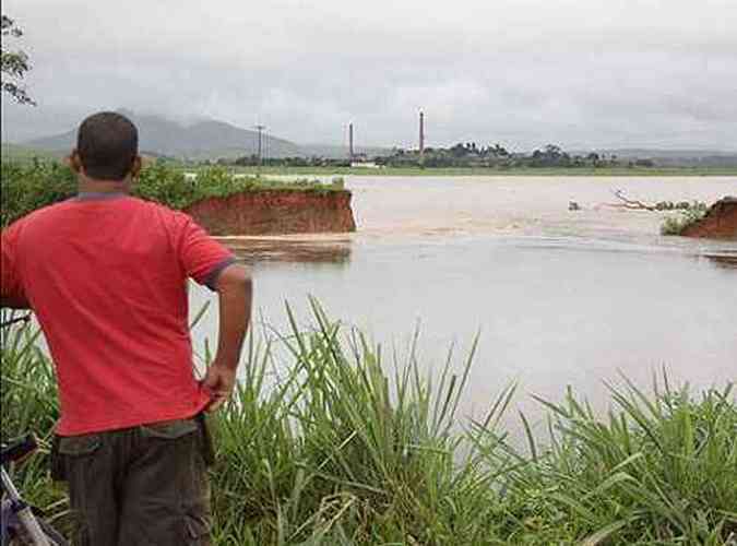 Homem observa local do rompimento do dique da Lagoa da Ona, tendo ao fundo a Usina de Outeiro, no Norte do Rio (foto: Silsio Corra - Folha da Manh)