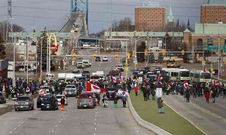 Uma linha de polcia empurra os manifestantes e seus veculos enquanto eles limpam um bloqueio na entrada da Ponte Ambassador, que estava selando o fluxo de trfego comercial sobre a ponte para o Canad de Detroit, em 12 de fevereiro , 2022 em Windsor, Canad