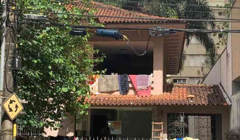 Fachada da casa, com roupas na varanda.