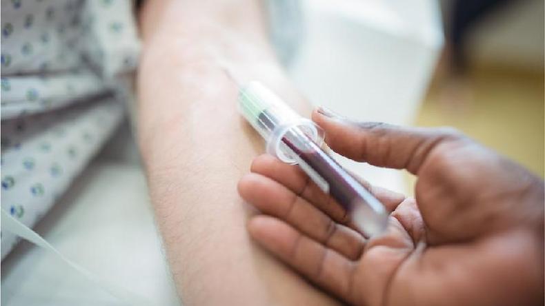 Foto de sangue sendo retirado de um brao por uma seringa