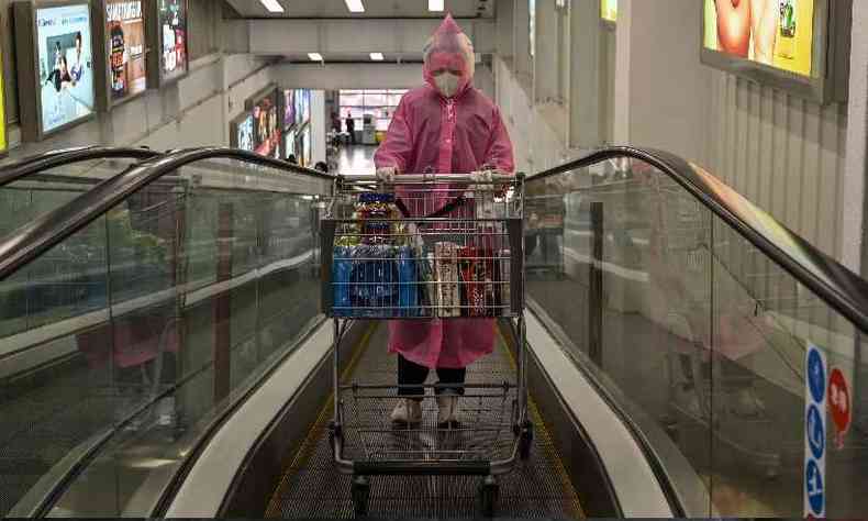 Mulher sozinha e toda protegida vai s compras no supermercado(foto: Hector RETAMAL / AFP)