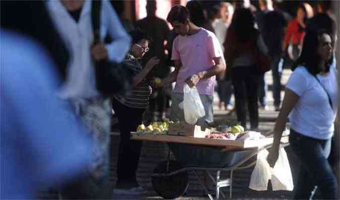Flagrante de infrao dupla nas ruas da cidade: ambulante irregular vende frutas e embala com sacola plstica(foto: Leandro Couri/EM/DA PRESS)