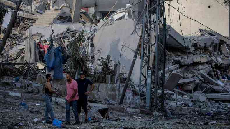 Palestinos ao lado de um prdio demolido na Cidade de Gaza