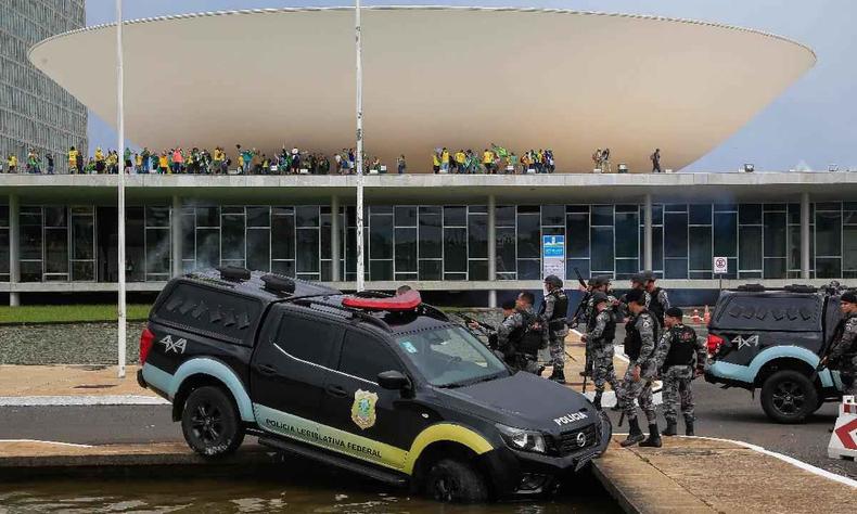 'O momento que estamos vivendo é muito delicado, porque não se sabe até onde as investigações vão chegar'(foto: Sergio Lima/AFP) Membros da Polícia Legislativa Federal ao lado de um veículo que colidiu com uma fonte enquanto apoiadores do ex-presidente brasileiro Jair Bolsonaro invadem o Congresso Nacional em Brasília em 8 de janeiro de 2023.