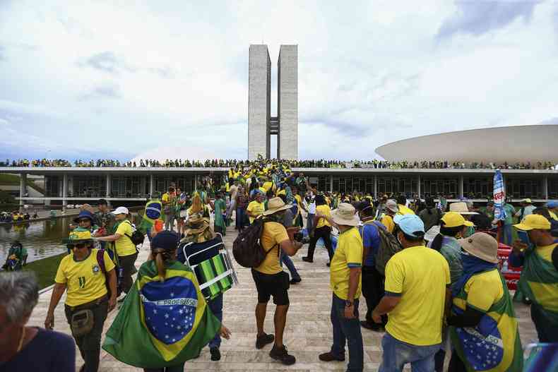 Manifestantes usando camisas amarelas e portando bandeiras do Brasil invadindo Congresso Nacional 