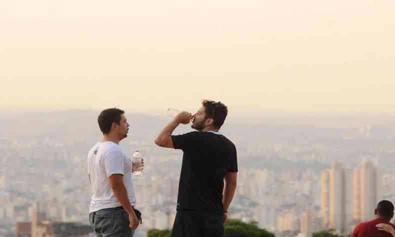 Homem bebe gua acompanhado de outro na Praa do Papa, em BH 