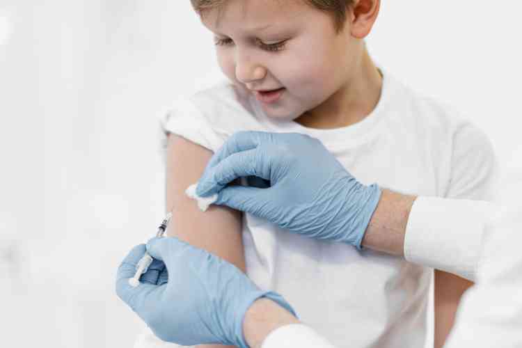 Menino tomando vacina no brao