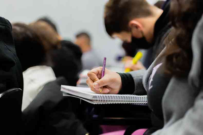 estudante escrevendo em um caderno