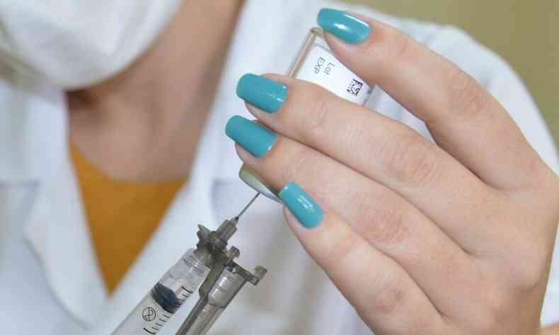 Enfermeira com dose de vacina nas mos