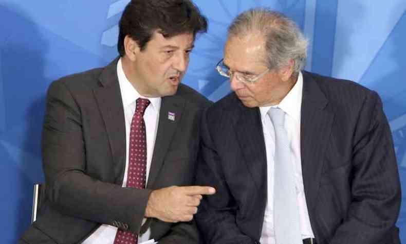 Mandetta (esq) conversa com Guedes em cerimnia oficial do anncio do 13 do Bolsa Famlia(foto: Wilson Dias/Agncia Brasil)