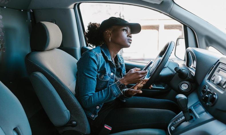 Mulher no banco de motorista olhando para cima