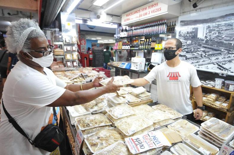 Mrcio Roberto recebe o bacalhau da mo do vendedor