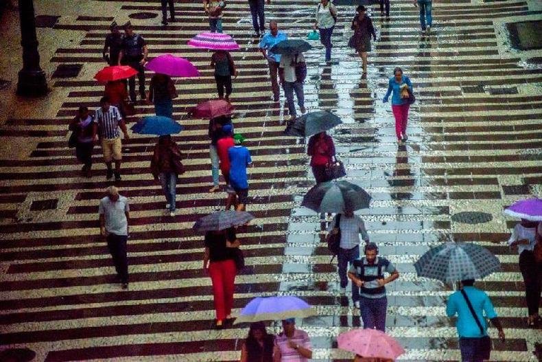 Migração, fecundidade, mortalidade... Esses e outros fatores explicam a distribuição da população brasileira por regiões, idades e sexo(foto: Cris Faga/NurPhoto via Getty Images) Pessoas caminhando em calçada em dia chuvoso; algumas carregam guarda-chuva