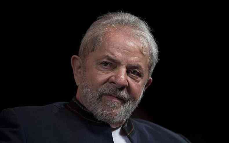 Lula olha para câmara em fundo preto