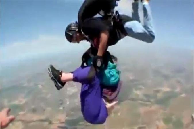 A idosa de quase 80 anos ficou presa pelas pernas e teve que se segurar para n�o cair durante um salto de paraquedas(foto: Reprodu��o Youtube)