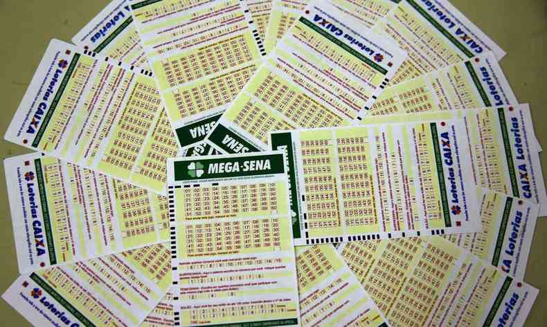 Na imagem h vrios bilhetes da Mega Sena espalhados em formato circular em uma mesa 