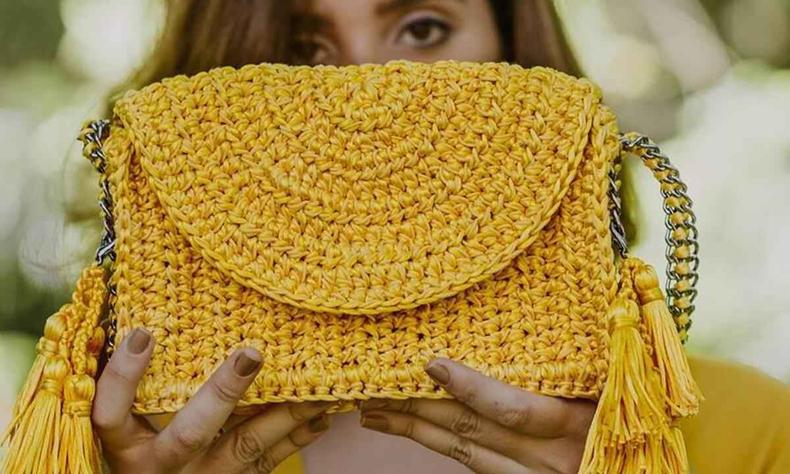 Modelo segura bolsa amarela criada pela marca Catarina Mina 