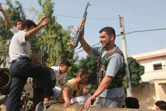 Rebeldes comemoram captura de tanque do exrcito srio em Anadan(foto: Iskandar Kat / AFP)