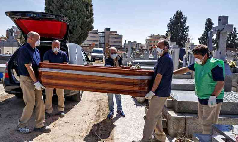 Em Madri, funcionrios dos cemitrios tomam todos os cuidados ao carregar os caixes (foto: Baldesca Samper/AFP)