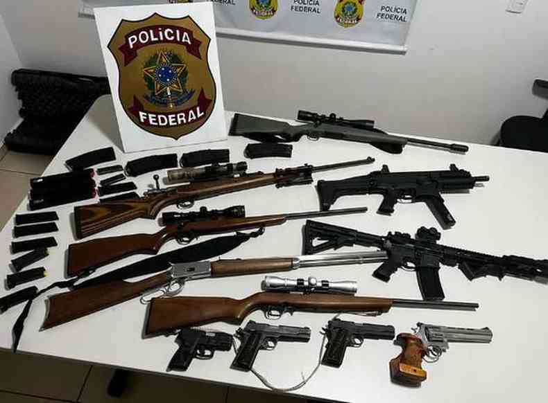 Rifles, pistolas e fuzis sobre mesa