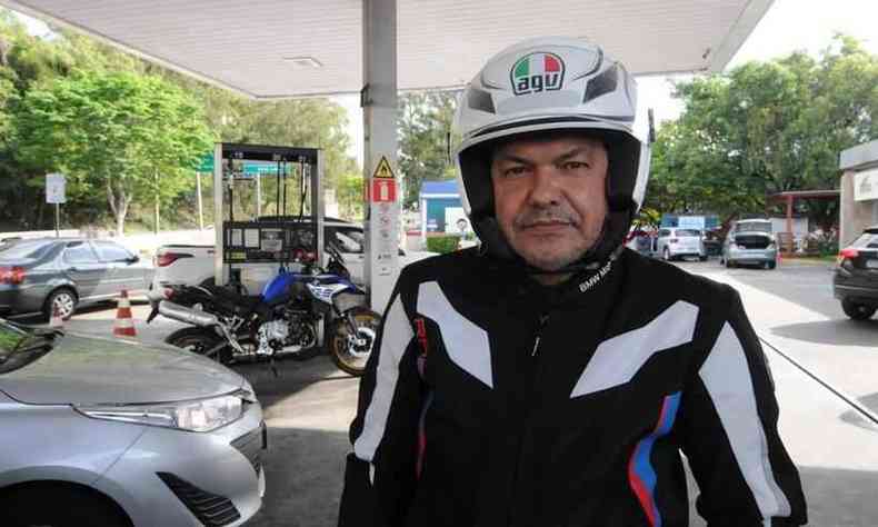 O motociclista Olavo Sales est com capacete na fila do posto de gasolina